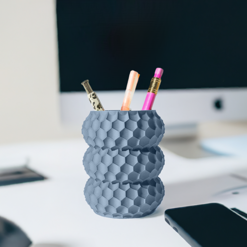 Portapenne blu a nido d'ape sopra ad una scrivania d'ufficio