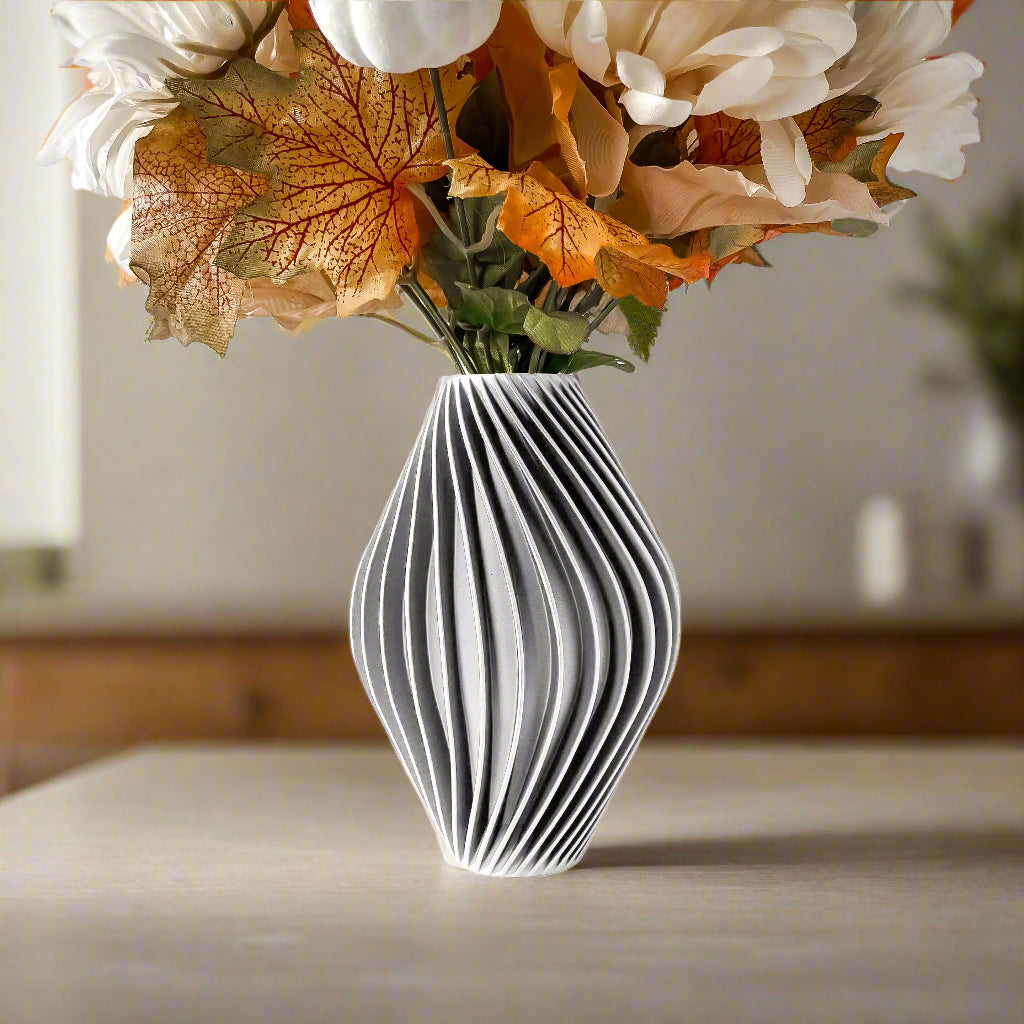 Vaso portafiori bianco con all'interno fiori secchi, all'interno di una cucina